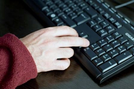 Fotografia de uma mão a usar o teclado de um computador 